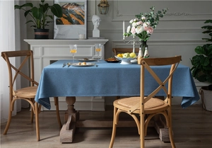 Detailed texture of thick dark blue faux linen tablecloth in a rustic vintage dining setting