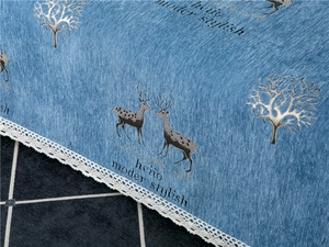 Macro detail of blue chenille sofa cover with deer pattern and white lace edge finish