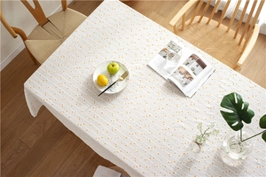 Macro detail of cotton rectangular tablecloth with yellow floral daisy jacquard pattern