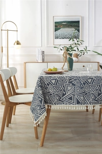 Detalle del mantel jacquard azul marino y gris con borlas y patrones triangulares
