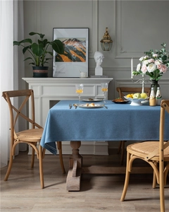 Detail view of thickened dark blue linen-textured tablecloth with clean hem and natural drape