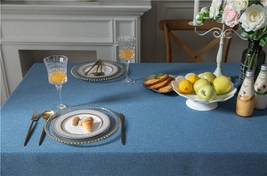 Detail of navy blue faux linen tablecloth showing thick fabric texture on a dining table