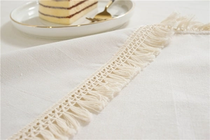 Close-up of cream tablecloth with fringe detail and elegant afternoon tea setting