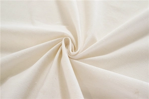 Close-up of thick off-white tablecloth fabric showing soft texture and tassel details