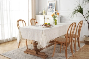 Close-up of yellow floral cotton tablecloth with elegant beige fringe tassels