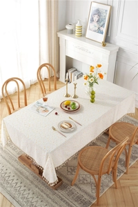 Detail of yellow polka dot cotton tablecloth featuring decorative fringe tassel edges