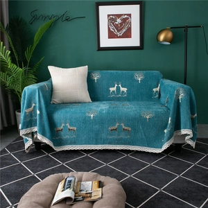 Close-up of blue chenille sofa cover with white elk pattern and delicate lace trim