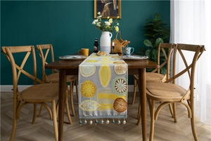 Detail of grey table runner with floral print and elegant beaded tassel fringe edge