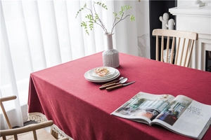 Macro detail of wine red rectangular tablecloth featuring elegant white tassel lace fringe
