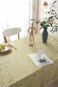Detalle de la tela jacquard geométrica amarillo mostaza con flecos blancos finos