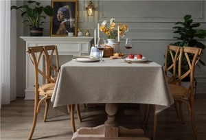 Detailed texture of thick beige faux linen rectangular tablecloth with elegant drape and weave