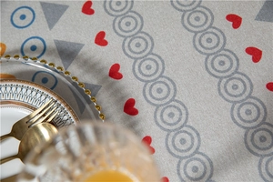 Close-up of thick cotton linen tablecloth with red heart and geometric circle patterns
