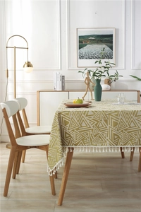 Detalle del patrón geométrico de triángulos y flecos en mantel de imitación lino