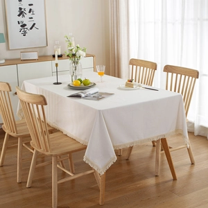 Thickened cream white tablecloth with tassel fringe on a rectangular wooden table