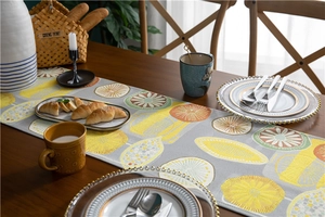 Close-up of modern polyester table runner with colorful citrus embroidery and fringe
