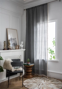 Close-up of grey cotton-polyester curtain with white herringbone pattern and tassel fringe