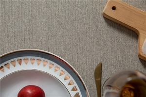 Close-up of grey herringbone textured tablecloth with white heart pattern ceramic plate
