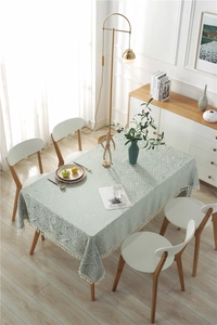 Detalle del mantel jacquard geométrico con elegantes borlas de flecos blancos