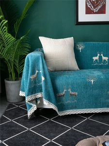 Detailed view of teal chenille sofa cover featuring elk patterns and white lace edges