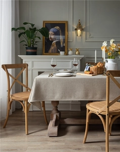 Macro view of beige linen-textured tablecloth on a rectangular dining table with elegant drape