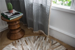 Detail of grey geometric herringbone curtain with cream cotton tassel fringe trim