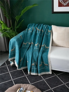 Close-up of thick chenille peacock blue sofa cover with reindeer pattern and white lace edge