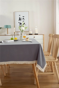 Detail einer modernen dunkelgrauen Baumwolltischdecke mit eleganten hellen Fransen