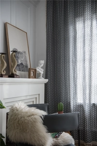 Detail of dark grey herringbone curtains with decorative tassels in a modern living room