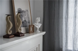 Close-up of grey and white herringbone pattern curtain with elegant drape and texture