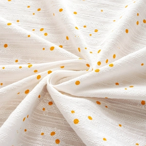 Pastel cream cotton tablecloth featuring yellow daisy jacquard and orange polka dot patterns