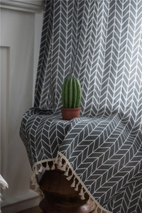 Detail of grey geometric pattern curtain with woven tassels and cotton texture
