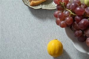 Detail of light gray herringbone fabric tablecloth with natural woven texture and fruit