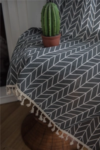 Detail view of grey chevron patterned fabric with ivory decorative tassels