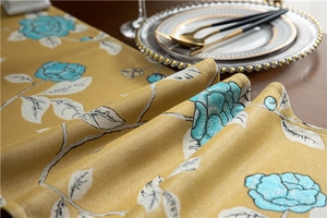Detailed close-up of mustard yellow polyester table runner with blue rose floral jacquard