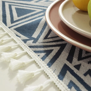 Camino de mesa jacquard moderno con triángulos geométricos azules y borlas blancas