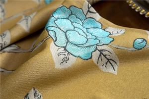 Macro shot of high-end jacquard floral fabric detail with intricate blue flower embroidery