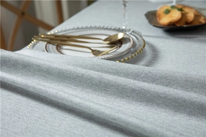 Close-up of light gray herringbone fabric tablecloth with a thick cotton-linen texture
