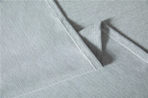 Close-up of light grey tablecloth showing detailed herringbone weave and neat hemmed edges