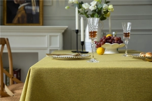 Detail of ginger yellow linen textured tablecloth with elegant heavy drape and weave