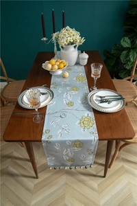 Detail of light blue table runner with yellow floral print and beaded tassel decor