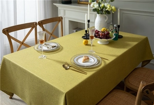 Close-up of bright yellow linen-textured tablecloth with clean edges and fine fabric detail