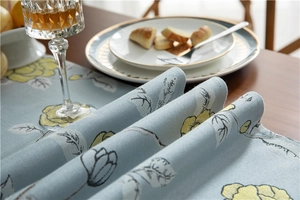 Detail of light blue table runner showing rose floral pattern and thick woven texture