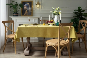 Close-up of thick yellow linen-textured tablecloth fabric with neat edge stitching