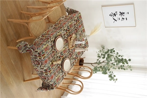 Detail of bohemian geometric tablecloth with colorful patterns on a wooden table