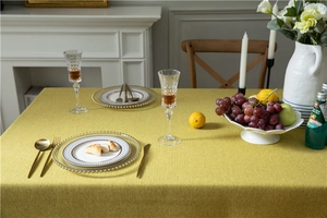 Close-up of thick mustard green linen-textured tablecloth showing woven fabric details