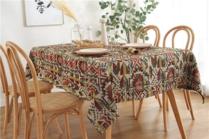Detailed close-up of Bohemian geometric pattern tablecloth on a wooden dining table