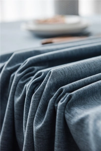 Close-up of gray-blue textured polyester tablecloth featuring elegant tassel lace edge