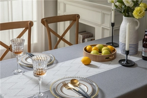 Detail of grey tablecloth paired with a white geometric jacquard pattern table runner