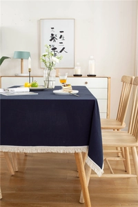 Detail der dunkelblauen Baumwolltischdecke mit zarter cremefarbener Quastenkante