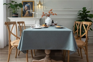 Close-up of blue-gray linen-textured tablecloth with elegant drape in a modern home